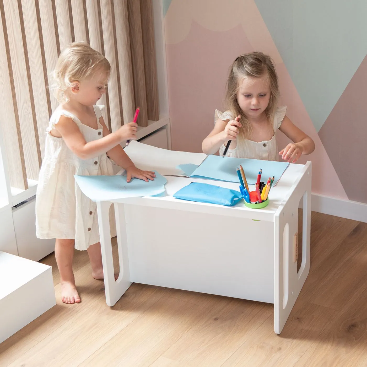 Deux fillettes à la table blanche pour enfant KiddyMoon dans une chambre lumineuse